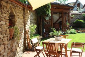 un patio con mesa, sillas y pared de piedra. en Privat pri Hradbach, en Levoča