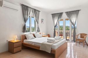 a bedroom with a large bed with windows at Agathi Sun Set in Rhodes Town