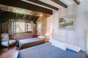 een hotelkamer met 2 bedden en een stoel bij La Posada de Langre in Langre