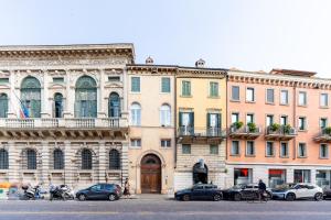 a large building with cars parked in front of it at [2 minutes walk from Verona Arena]Luxury Apartment in Verona