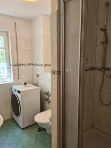 ein Badezimmer mit einer Waschmaschine und einem WC in der Unterkunft Ferienwohnung T24 in Graal-Müritz