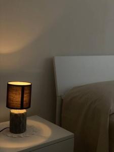 a lamp sitting on a table next to a bed at “Temesa House” il mare a due passi da te! in Campora San Giovanni