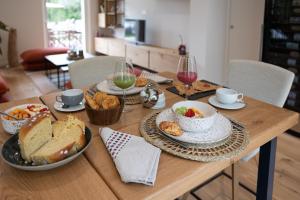 una mesa de madera cubierta con tazones y platos de comida en Domaine Baruteau, en Soustons