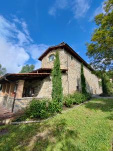 a stone house with a tree in front of it at Villa Giulia Fashion B&B in Strada