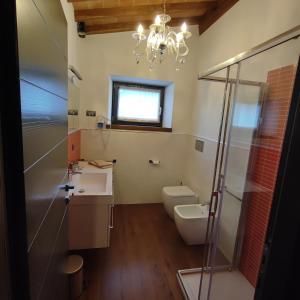 a bathroom with a sink and a toilet and a chandelier at Villa Giulia Fashion B&B in Strada
