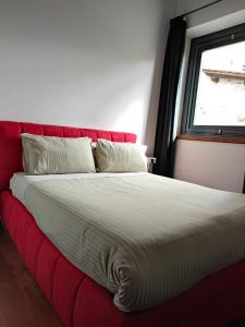 a red bed in a room with a window at Villa Giulia Fashion B&B in Strada