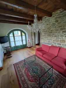 a living room with a red couch and a stone wall at Villa Giulia Fashion B&B in Strada