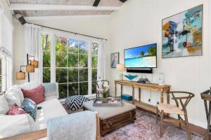 Una sala de estar con un sofá blanco y una mesa. en Tropical Estate w/ Guesthouse & Pool. Sleeps 8!, en West Palm Beach