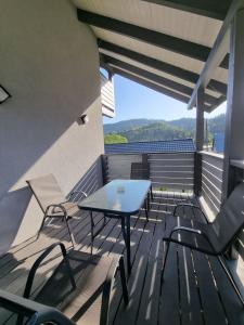 a patio with a table and chairs on a deck at Prostir 65 in Slavske