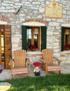 un osito de peluche sentado entre dos sillas frente a un edificio en Alilandia - Casa Vacanza, en Valdobbiadene