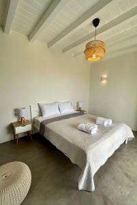 a bedroom with a large bed and a chandelier at Serifos Blue in Rámos