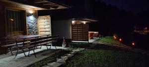 a backyard at night with a bench and a table at LEŚNE ZACISZE OCHOTNICA in Ochotnica Górna +39 photos
