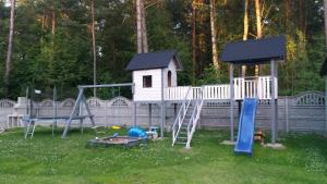 a playground with a play house and a slide at Leśny Zakątek - Domek Morze in Ustka