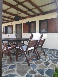 een houten tafel en stoelen op een patio bij Kalliopi's House in Aroyí
