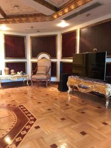 a large living room with a piano and a chair at شقة فخمة علي كورنيش النيل - المعادي in Cairo