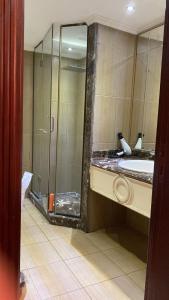 W łazience znajduje się prysznic ze szklanymi drzwiami. w obiekcie شقة فخمة علي كورنيش النيل - المعادي w Kairze
