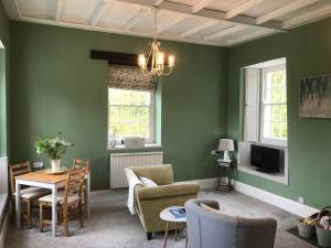 salon z zielonymi ścianami, stołem i krzesłami w obiekcie The Cornish Peak by StayStaycations w mieście Camelford