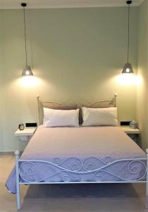 a bedroom with a bed with two lights above it at Terranova beach apartment - Menta in Ýpsos