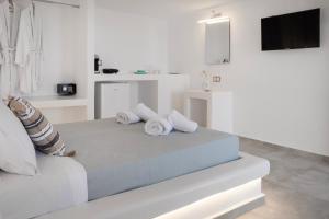 a white bedroom with a large bed with pillows at Feel Breeze in Mýkonos City