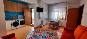a living room with a red couch and a kitchen at Yellow House Mamaia Nord in Mamaia Sat/Năvodari