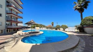 a swimming pool with an umbrella next to a building at El Trampolí By El Conserje in Denia