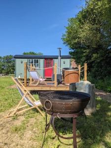 einen Grill im Gras mit einem Haus im Hintergrund in der Unterkunft Kenny’s Hut in Cowfold