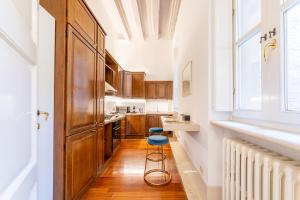 a kitchen with wooden cabinets and a blue stool at [2 minutes walk from Verona Arena]Luxury Apartment in Verona