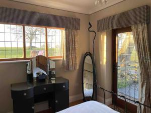 a bedroom with a dresser and a mirror and a bed at The Old Telephone Exchange - surrounded by fields! in Harrogate