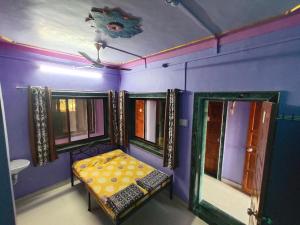 a room with a bed in a room with purple walls at SHANTI GUEST HOUSE in Srīvardhan