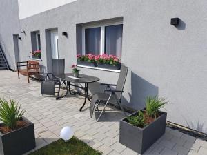 un patio con mesa, sillas y plantas en Apartment Grafenauer, en Sankt Gallenkirch