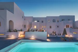 una villa con piscina di notte di VOCA HOTEL & SUITES a Kamari