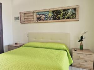 a bedroom with a green bed and a painting on the wall at B&B Monteleo Salento in Morciano di Leuca +46 photos