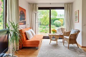 ein Wohnzimmer mit einem orangenen Sofa und einem Tisch in der Unterkunft Idyll am Weinberg in Rhodt unter Rietburg