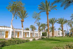 einen Außenblick auf ein Gebäude mit Palmen in der Unterkunft Menaville Resort in Hurghada