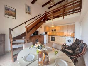 uma sala de jantar com uma mesa e uma escada em Appartement Fréjus, 2 pièces, 6 personnes - FR-1-226A-42 em Fréjus