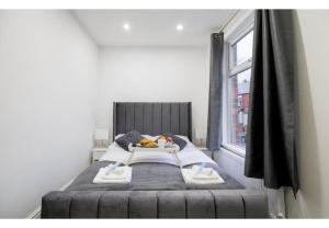 a small bed in a room with a window at Stunning Bolton abode – Pool table – Parking in Bolton