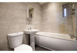 uma casa de banho com um WC, um lavatório e uma banheira em Stunning Bolton abode – Pool table – Parking em Bolton