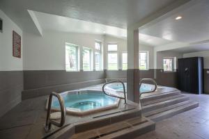 uma grande casa de banho com jacuzzi com escadas em Gold Camp C75 em Breckenridge