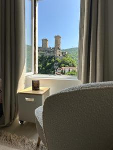 a living room with a view of a castle from a window at cocoon 52 m2 new, beautiful view castle and mountain in Foix