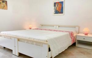 ein weißes Bett mit zwei Lampen an zwei Tischen in der Unterkunft Villetta Torre Vado in Torre Vado