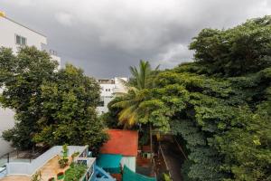 - une vue sur un jardin arboré et un bâtiment dans l'établissement Home Awaits 357, à Bangalore