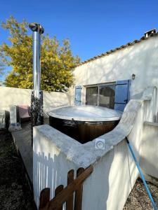 a hot tub in a backyard with a fence at Mas Du Pont Rouge in Sylvéréal