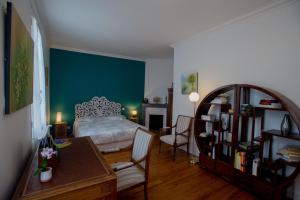 a bedroom with a bed and a table and chairs at d’un jardin à l’autre in Tarbes