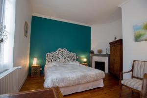 um quarto com uma cama e uma parede verde em d’un jardin à l’autre em Tarbes
