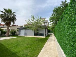 a house with a large green hedge at Ortaca merkezde 2+1 eşyalı bahçeli müstakil ev, Villa Ortaca in Ortaca
