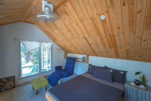 a bedroom with a bed and two blue chairs at Homie Hava Homestay in Lang Co