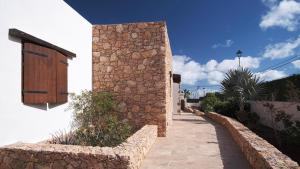 Los Estancos的住宿－Pueblo Canario，人行道旁的石墙建筑