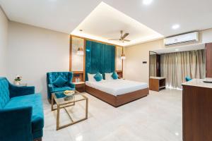 a hotel room with a bed and a blue chair at Enrise by Sayaji Harda in Harda +51 photos