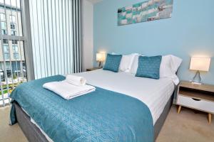 um quarto com uma cama grande e uma janela grande em Brightleap Apartments - The Hub em Milton Keynes