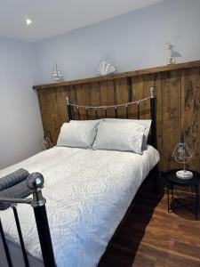 a bedroom with a bed with a wooden headboard at 2 hunters lane Donaghadee in Donaghadee